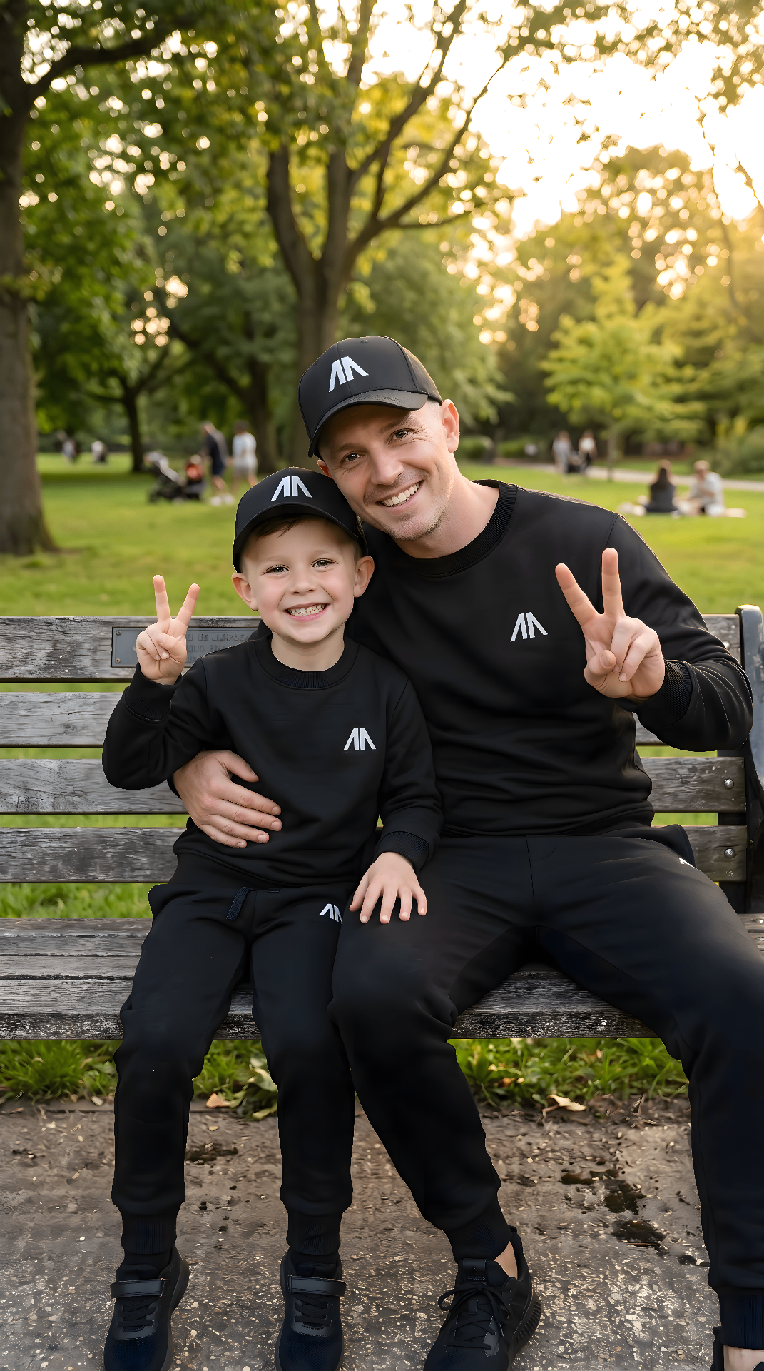 Vader en zoon in matchende zwarte sets op een parkbank